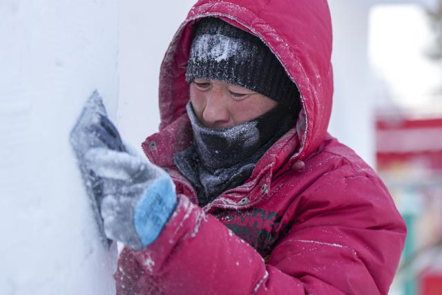 (251227) -- HARBIN, Dec. 27, 2025 (Xinhua) -- An artisan works with a snow sculpture at the venue of the 38th Sun Island International Snow Sculpture Art Expo in Harbin, northeast China's Heilongjiang Province, Dec. 26, 2025. The 38th Sun Island International Snow Sculpture Art Expo opened here for trial on Saturday, with an exhibition area of 1.5 million square meters and a snow-using volume of 120,000 cubic meters. (Xinhua/Wang Song)