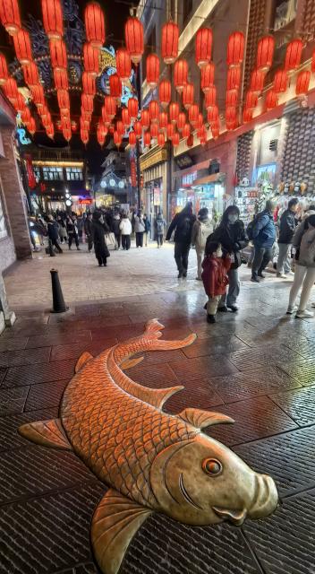 (251227) -- BEIJING, Dec. 27, 2025 (Xinhua) -- People enjoy night view on the Qianmen pedestrian street in Beijing, capital of China, Dec. 26, 2025. As the New Year approaches, the Qianmen pedestrian street, a landmark commercial street in Beijing, is decorated with various festoons. (Xinhua/Li Xin)