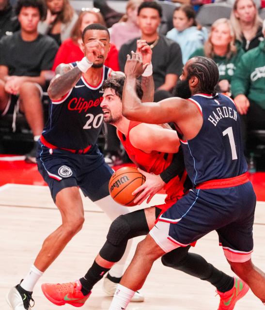 (251227) -- PORTLAND, Dec. 27, 2025 (Xinhua) -- Deni Avdija (C) of Portland Trail Blazers breaks through past James Harden (R) of Los Angeles Clippers during the 2025-2026 NBA regular season match between Portland Trail Blazers and Los Angeles Clippers in Portland, the United States, Dec. 26, 2025. (Photo by Sun Yuxuan/Xinhua)