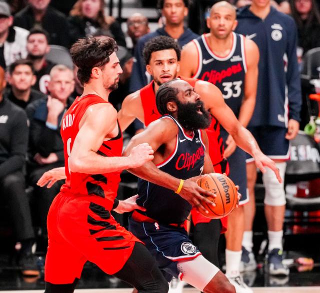 (251227) -- PORTLAND, Dec. 27, 2025 (Xinhua) -- James Harden (C) of Los Angeles Clippers breaks through during the 2025-2026 NBA regular season match between Portland Trail Blazers and Los Angeles Clippers in Portland, the United States, Dec. 26, 2025. (Photo by Sun Yuxuan/Xinhua)