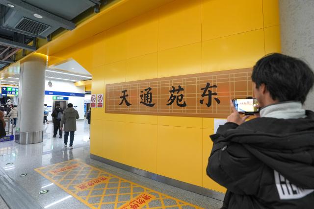 (251227) -- BEIJING, Dec. 27, 2025 (Xinhua) -- A passenger takes photos at Tiantongyuan East Station of Beijing Subway Line 18 in Beijing, capital of China, Dec. 27, 2025. Three new subway lines opened on Saturday in Beijing, adding the city's total urban rail transit length to 909 kilometers. (Xinhua/Ju Huanzong)