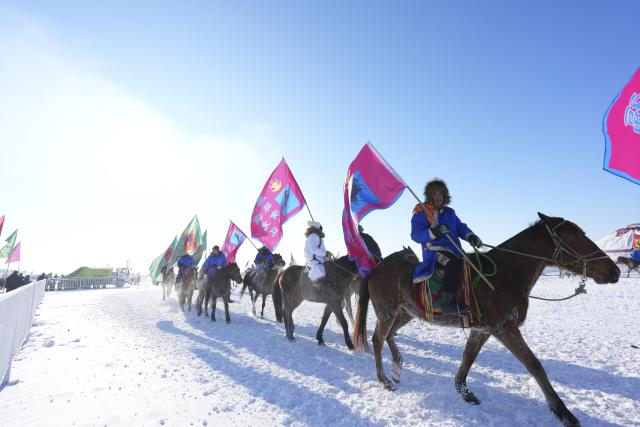 (251227) -- DAQING, Dec. 27, 2025 (Xinhua) -- People ride horses during a winter fishing event of a Nadam fair in Mongolian Autonomous County of Dorbod, Daqing City, northeast China's Heilongjiang Province, Dec. 27, 2025. An ice and snow Nadam fair featuring winter fishing kicked off here on Saturday. The integrated development fishery, and cultural and tourism industry in Dorbod has not only boosted tourism market, but also increased the income of local fishermen. (Xinhua/Wang Song)