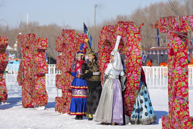 (251227) -- DAQING, Dec. 27, 2025 (Xinhua) -- Tourists pose for photos during a winter fishing event of a Nadam fair in Mongolian Autonomous County of Dorbod, Daqing City, northeast China's Heilongjiang Province, Dec. 27, 2025. An ice and snow Nadam fair featuring winter fishing kicked off here on Saturday. The integrated development fishery, and cultural and tourism industry in Dorbod has not only boosted tourism market, but also increased the income of local fishermen. (Xinhua/Wang Song)