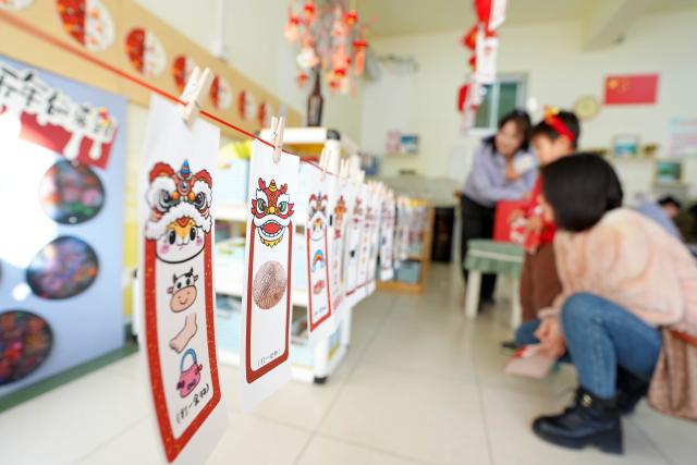 (251227) -- YINCHUAN, Dec. 27, 2025 (Xinhua) -- Children participate in a riddle guessing activity at a kindergarten in Yinchuan, northwest China's Ningxia Hui Autonomous Region, Dec. 27, 2025. As the New Year approaches, a kindergarten in Yinchuan City held an activity and invited inheritors of intangible cultural heritage to promote lion dance, paper-cutting making and sugar painting. (Xinhua/Wang Peng)