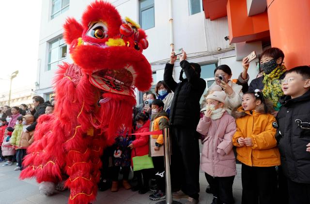 (251227) -- YINCHUAN, Dec. 27, 2025 (Xinhua) -- Children watch a lion dance performance at a kindergarten in Yinchuan, northwest China's Ningxia Hui Autonomous Region, Dec. 27, 2025. As the New Year approaches, a kindergarten in Yinchuan City held an activity and invited inheritors of intangible cultural heritage to promote lion dance, paper-cutting making and sugar painting. (Xinhua/Wang Peng)