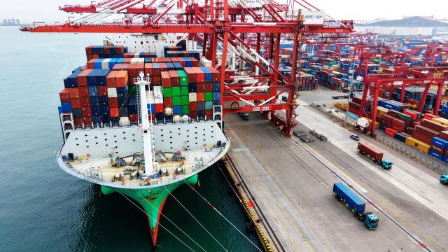 (251227) -- JINAN, Dec. 27, 2025 (Xinhua) -- This aerial drone photo taken on Dec. 27, 2025 shows a cargo ship loading and unloading containers at Qingdao Port in east China's Shandong Province. Shandong's port cargo throughput this year exceeded 1.9 billion tonnes on Saturday, with container volume surpassing 47 million TEUs. (Photo by Yu Fangping/Xinhua)