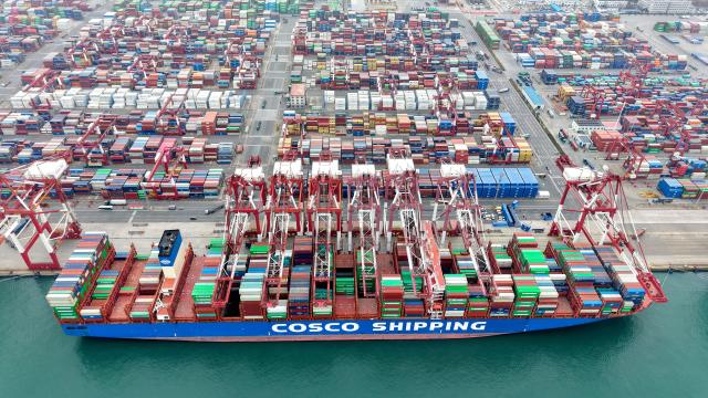 (251227) -- JINAN, Dec. 27, 2025 (Xinhua) -- This aerial drone photo taken on Dec. 27, 2025 shows a cargo ship loading and unloading containers at Qingdao Port in east China's Shandong Province. Shandong's port cargo throughput this year exceeded 1.9 billion tonnes on Saturday, with container volume surpassing 47 million TEUs. (Photo by Yu Fangping/Xinhua)