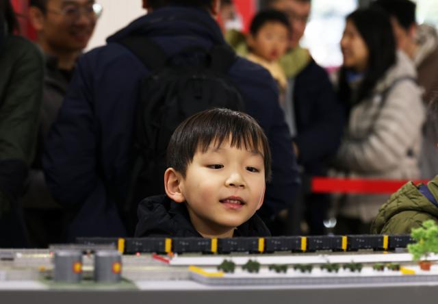 (251227) -- SHANGHAI, Dec. 27, 2025 (Xinhua) -- A boy visits a model train exhibition in Shanghai, east China, Dec. 27, 2025. The theme exhibition and related special activities were held at Shanghai Mass Art Center on Saturday. More than 50 model trains shuttled among ten theme scenes, presenting visitors with a wonderful miniature world about trains and railways. (Xinhua/Liu Ying)