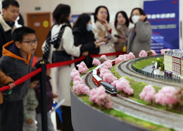 (251227) -- SHANGHAI, Dec. 27, 2025 (Xinhua) -- People visit a model train exhibition in Shanghai, east China, Dec. 27, 2025. The theme exhibition and related special activities were held at Shanghai Mass Art Center on Saturday. More than 50 model trains shuttled among ten theme scenes, presenting visitors with a wonderful miniature world about trains and railways. (Xinhua/Liu Ying)
