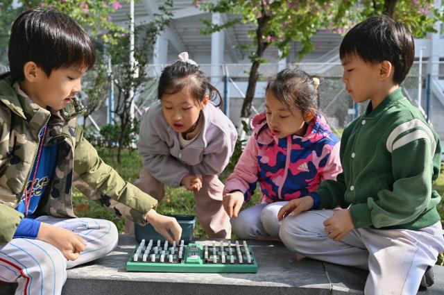 (251227) -- FOSHAN, Dec. 27, 2025 (Xinhua) -- Children play an intelligent military chess produced by Giiker outside a stadium in Guangzhou, south China's Guangdong Province, Dec. 27, 2025. As traditional toys are stuck in price and homogenization competition, a batch of smart educational toys is quietly opening up new markets at home and abroad.
   In this emerging market segment, Giiker from Shunde of Foshan City, stands out. Founded in 2018, Giiker started with a Rubik's Cube product and has reached an annual gross merchandise volume of over 500 million yuan (about 71.36 million U.S. dollars) in just six years.
   Founder Su Ziming said that unlike the traditional toy industry's strategy of pursuing rapid launch and extensive distribution of new products, Giiker prefers to spend one to two years refining a product, emphasizing a long-term life cycle and high quality.
   Another outstanding company in this market segment is GANCUBE, a technology company also based in south China's Guangdong Province. It entered the market in 2014,  and has now developed into a smart competitive platform covering smart hardware, AI algorithms, and IoT ecosystem.  In the global smart competitive toy segment, GANCUBE holds approximately 20 percent of the market share. 
   Behind the rapid development lies its continuous R&D and manufacturing investment. GANCUBE has multiple production bases, including a digital factory of over 15,000 square meters. The team has a high proportion of R&D personnel, and it has even independently developed an automated cube production line that is rare in the industry. Its products are sold through platforms like Amazon and Tmall to over 100 countries and regions.
   The rise of smart educational toys reflects not only the upgrade of China's toy industry but also the evolution of educational concepts and consumption trends. As "learning through play" becomes a consensus, this market segment is attracting more and more innovators. (Xinhua/Huo Siying)