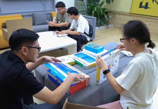 (251227) -- FOSHAN, Dec. 27, 2025 (Xinhua) -- Staff members of Giiker discuss the packaging of products in Shunde, Foshan City, south China's Guangdong Province, Oct. 29, 2025. As traditional toys are stuck in price and homogenization competition, a batch of smart educational toys is quietly opening up new markets at home and abroad.
   In this emerging market segment, Giiker from Shunde of Foshan City, stands out. Founded in 2018, Giiker started with a Rubik's Cube product and has reached an annual gross merchandise volume of over 500 million yuan (about 71.36 million U.S. dollars) in just six years.
   Founder Su Ziming said that unlike the traditional toy industry's strategy of pursuing rapid launch and extensive distribution of new products, Giiker prefers to spend one to two years refining a product, emphasizing a long-term life cycle and high quality.
   Another outstanding company in this market segment is GANCUBE, a technology company also based in south China's Guangdong Province. It entered the market in 2014,  and has now developed into a smart competitive platform covering smart hardware, AI algorithms, and IoT ecosystem.  In the global smart competitive toy segment, GANCUBE holds approximately 20 percent of the market share. 
   Behind the rapid development lies its continuous R&D and manufacturing investment. GANCUBE has multiple production bases, including a digital factory of over 15,000 square meters. The team has a high proportion of R&D personnel, and it has even independently developed an automated cube production line that is rare in the industry. Its products are sold through platforms like Amazon and Tmall to over 100 countries and regions.
   The rise of smart educational toys reflects not only the upgrade of China's toy industry but also the evolution of educational concepts and consumption trends. As "learning through play" becomes a consensus, this market segment is attracting more and more innovators. (Xinhua/Mao Siqian)