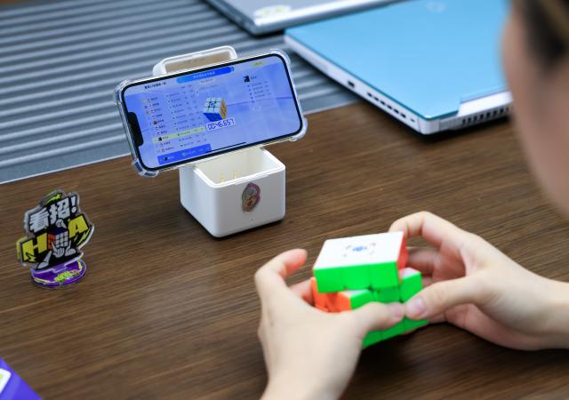 (251227) -- FOSHAN, Dec. 27, 2025 (Xinhua) -- An employee of the technology company GANCUBE participates in a Rubik's Cube competition held within the company in Shunde, Foshan City, south China's Guangdong Province, Oct. 29, 2025. As traditional toys are stuck in price and homogenization competition, a batch of smart educational toys is quietly opening up new markets at home and abroad.
   In this emerging market segment, Giiker from Shunde of Foshan City, stands out. Founded in 2018, Giiker started with a Rubik's Cube product and has reached an annual gross merchandise volume of over 500 million yuan (about 71.36 million U.S. dollars) in just six years.
   Founder Su Ziming said that unlike the traditional toy industry's strategy of pursuing rapid launch and extensive distribution of new products, Giiker prefers to spend one to two years refining a product, emphasizing a long-term life cycle and high quality.
   Another outstanding company in this market segment is GANCUBE, a technology company also based in south China's Guangdong Province. It entered the market in 2014,  and has now developed into a smart competitive platform covering smart hardware, AI algorithms, and IoT ecosystem.  In the global smart competitive toy segment, GANCUBE holds approximately 20 percent of the market share. 
   Behind the rapid development lies its continuous R&D and manufacturing investment. GANCUBE has multiple production bases, including a digital factory of over 15,000 square meters. The team has a high proportion of R&D personnel, and it has even independently developed an automated cube production line that is rare in the industry. Its products are sold through platforms like Amazon and Tmall to over 100 countries and regions.
   The rise of smart educational toys reflects not only the upgrade of China's toy industry but also the evolution of educational concepts and consumption trends. As "learning through play" becomes a consensus, this market segment is attracting more and more innovators. (Xinhua/Huo Siying)
