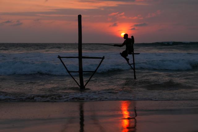 (251228) -- BEIJING, Dec. 28, 2025 (Xinhua) -- A fisherman fishes on a stilt at a beach in Koggala, Sri Lanka, Dec. 26, 2025. (Photo by Thilina Kaluthotage/Xinhua)