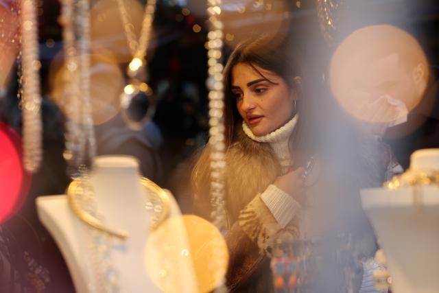 (251228) -- BEIJING, Dec. 28, 2025 (Xinhua) -- A woman walks past a jewelry stall at a Christmas market at Piazza Navona in Rome, Italy, Dec. 27, 2025. (Xinhua/Li Jing)