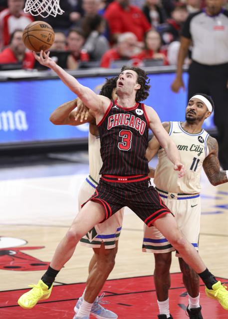 (251228) -- CHICAGO, Dec. 28, 2025 (Xinhua) -- Josh Giddey (C) of Chicago Bulls goes for a lay-up during NBA regular season basketball game between Milwaukee Bucks and Chicago Bulls at United Center in Chicago, the United States, on Dec. 27, 2025. (Photo by Joel Lerner/Xinhua)