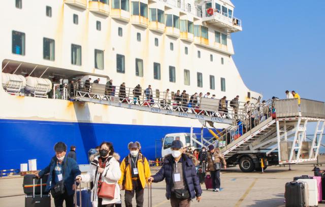 (251228) -- LIANYUNGANG, Dec. 28, 2025 (Xinhua) -- Tourists from South Korea get off from the "Harmony Yungang" cruise ship at Lianyungang Port in Lianyungang City, east China's Jiangsu Province, Dec. 28, 2025. A total of 255 South Korean tourists arrived in Lianyungang aboard the "Harmony Yungang" cruise ship, commencing a five-day New Year tour in China. This marks the largest group of South Korean travelers received at Lianyungang port passenger terminal since China's visa-free policy for South Korean citizens. (Photo by Wang Jianmin/Xinhua)