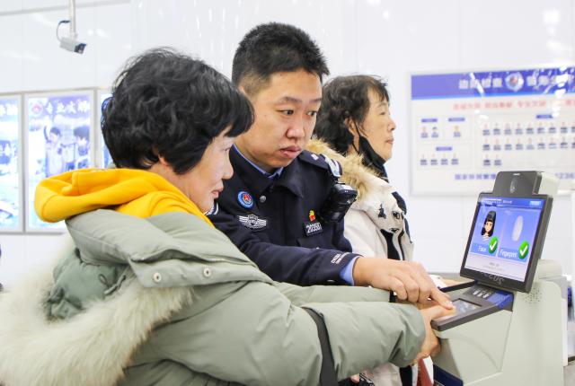 (251228) -- LIANYUNGANG, Dec. 28, 2025 (Xinhua) -- A police officer helps a South Korean tourist scan fingerprint at the arrival hall of the international passenger terminal of Lianyungang Port in Lianyungang City, east China's Jiangsu Province, Dec. 28, 2025. A total of 255 South Korean tourists arrived in Lianyungang aboard the "Harmony Yungang" cruise ship, commencing a five-day New Year tour in China. This marks the largest group of South Korean travelers received at Lianyungang port passenger terminal since China's visa-free policy for South Korean citizens. (Photo by Wang Jianmin/Xinhua)