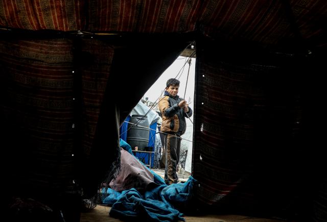 (251229) -- GAZA, Dec. 29, 2025 (Xinhua) -- A displaced Palestinian boy is seen outside his tent at the Jabalia refugee camp in the northern Gaza Strip, on Dec. 28, 2025. A child and a woman were killed in a severe storm affecting the Gaza Strip, the region's Civil Defense announced Sunday. (Photo by Rizek Abdeljawad/Xinhua)