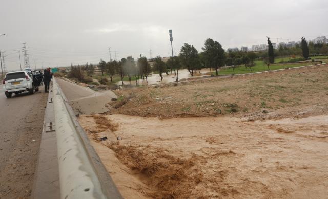 (251229) -- NEGEV, Dec. 29, 2025 (Xinhua) -- People inspect floodwater in southern Israel on Dec. 28, 2025. Israel's winter rainy season frequently brings floods. (Photo by Gil Cohen Magen/Xinhua)