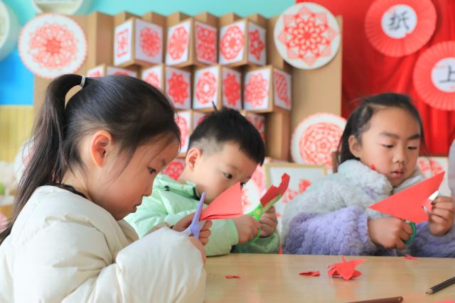 (251229) -- BEIJING, Dec. 29, 2025 (Xinhua) -- Children make paper-cut decorations in a kindergarten in Jiaozuo City, central China's Henan Province, Dec. 29, 2025. Various activities are held across China to celebrate the upcoming new year. (Photo by Huang Fuxing/Xinhua)