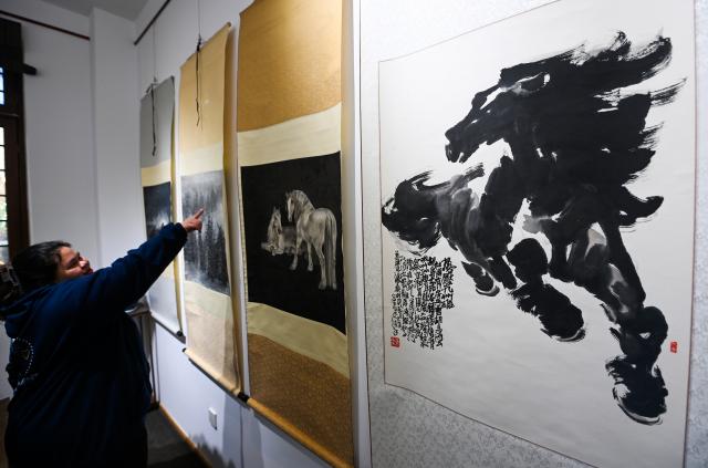 (251229) -- BEIJING, Dec. 29, 2025 (Xinhua) -- Visitors view horse paintings at an exhibition in north China's Tianjin, Dec. 29, 2025. Various activities are held across China to celebrate the upcoming new year. (Xinhua/Zhao Zishuo)