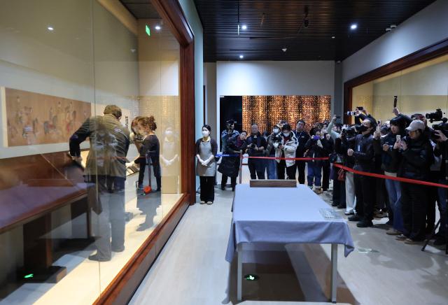 (251229) -- SHENYANG, Dec. 29, 2025 (Xinhua) -- Staff members prepare a Song Dynasty (960-1279 AD) replica of the painting "Lady Guoguo's Spring Outing" for exhibition at Liaoning Provincial Museum with the presence of journalists in Shenyang, northeast China's Liaoning Province, Dec. 29, 2025. The painting, attributed to Tang Dynasty (618-907 AD) court painter Zhang Xuan, is one of the figure painting masterpieces depicting aristocratic women. The work will be on display at Liaoning Provincial Museum from Dec. 30, 2025 to March 29, 2026. (Xinhua/Li Gang)