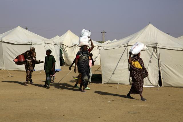 (251229) -- AL-DABBAH, Dec. 29, 2025 (Xinhua) -- Displaced people carry humanitarian aid at Al-Affad displacement camp in Al-Dabbah city, northern Sudan, Nov. 13, 2025. TO GO WITH: "Roundup: Sudan's 2025 -- a year of shifting fronts, deepening crises" (Photo by Mohamed Khidir/Xinhua)