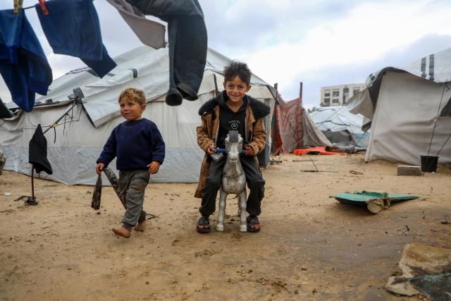(251229) -- GAZA, Dec. 29, 2025 (Xinhua) -- Displaced Palestinian children play outside during cold weather, at a temporary shelter near the Gaza port in Gaza City, Dec. 29, 2025. (Photo by Rizek Abdeljawad/Xinhua)