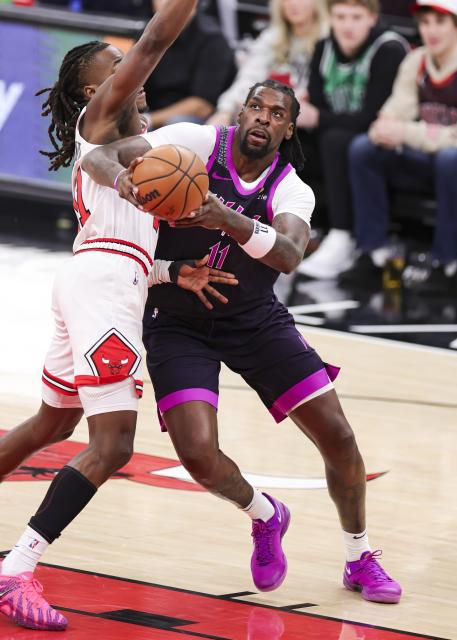 (251230) -- CHICAGO, Dec. 30, 2025 (Xinhua) -- Minnesota Timberwolves' Naz Reid (R) drives to the basket during the 2025-2026 NBA regular season basketball game between Minnesota Timberwolves and Chicago Bulls in Chicago, the United States, Dec. 29, 2025. (Photo by Joel Lerner/Xinhua)