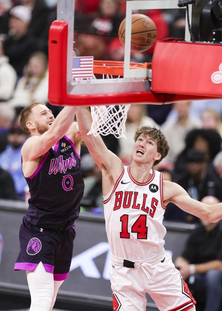 (251230) -- CHICAGO, Dec. 30, 2025 (Xinhua) -- Minnesota Timberwolves' Donte DiVincenzo (L) and Chicago Bulls' Matas Buzelis battle for a rebound during the 2025-2026 NBA regular season basketball game between Minnesota Timberwolves and Chicago Bulls in Chicago, the United States, Dec. 29, 2025. (Photo by Joel Lerner/Xinhua)