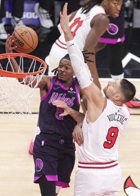 (251230) -- CHICAGO, Dec. 30, 2025 (Xinhua) -- Minnesota Timberwolves' Bones Hyland (L) goes to the basket against Chicago Bulls' Nikola Vucevic during the 2025-2026 NBA regular season basketball game between Minnesota Timberwolves and Chicago Bulls in Chicago, the United States, Dec. 29, 2025. (Photo by Joel Lerner/Xinhua)