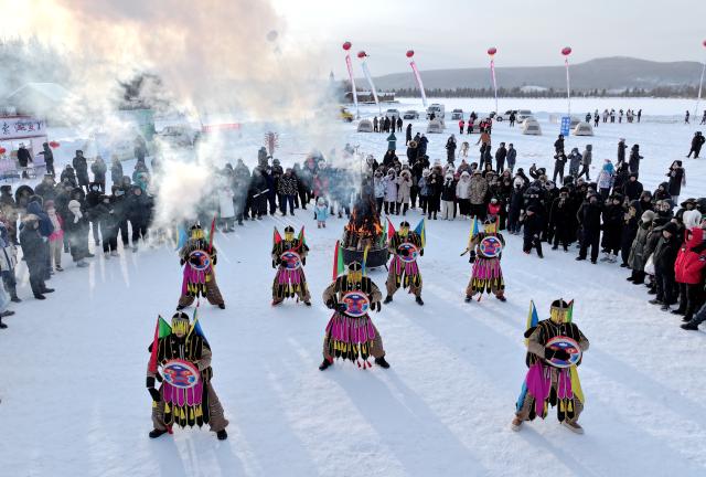 (251230) -- MOHE, Dec. 30, 2025 (Xinhua) -- Folk artists dance during a winter fishing event in Mohe, northeast China's Heilongjiang Province, Dec. 30, 2025. The event held on Tuesday showcased some customs and folk arts only found in Mohe. (Photo by Shao Tianli/Xinhua)
