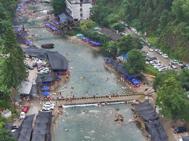 (251230) -- NANNING, Dec. 30, 2025 (Xinhua) -- An aerial drone photo shows tourists cooling off in the river at Zhongping Village of Xiangfen Township in Rongshui Miao Autonomous County, south China's Guangxi Zhuang Autonomous Region, July 19, 2025.
  Recent years saw local authorities in Guangxi boosting the development of tourism in the rural areas through a variety of cultural initiatives. (Xinhua/Huang Xiaobang)