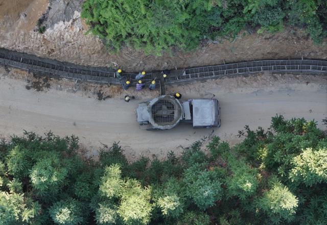 (251230) -- NANNING, Dec. 30, 2025 (Xinhua) -- A drone photo shows workers widening a road at Wuying Miao village in Rongshui Miao Autonomous County, south China's Guangxi Zhuang Autonomous Region, Nov. 27, 2025.
  Recent years saw local authorities in Guangxi boosting the development of tourism in the rural areas through a variety of cultural initiatives. (Xinhua/Huang Xiaobang)