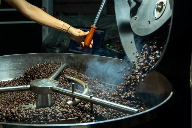 (251230) -- CHAMPASAK, Dec. 30, 2025 (Xinhua) -- A worker roasts coffee beans at a coffee plantation in Champasak Province, Laos, Dec. 17, 2025. TO GO WITH "Feature: Lao coffee's aroma goes global" (Photo by Ma Huaizhao/Xinhua)