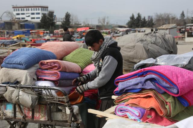 (251230) --  KABUL, Dec. 30, 2025 (Xinhua) -- An Afghan boy sells second-hand textiles in Kabul, Afghanistan, Dec. 29, 2025. TO GO WITH "Feature: Workforce finds hope amid rising hardships in Kabul, Afghanistan" (Photo by Saifurahman Safi/Xinhua)