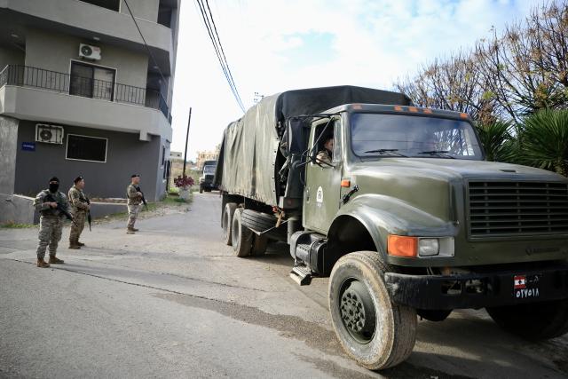 (251230) -- SIDON, Dec. 30, 2025 (Xinhua) -- Soldiers from the Lebanese army guard trucks carrying weapons received from the Ain al-Hilweh Palestinian refugee camp in Sidon, Lebanon, Dec. 30, 2025. The Lebanese army on Tuesday received the fifth batch of weapons handed over from Palestinian refugee camps in Lebanon, as part of a state-led plan to centralize arms under national authority. (Photo by Ali Hashisho/Xinhua)