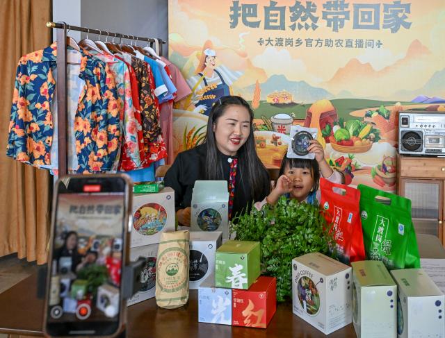 (251231) -- JINGHONG, Dec. 31, 2025 (Xinhua) -- Wei Chun (L) conducts a simulated livestreaming with a student who is on a study tour at a studio in Dadugang Township of Jinghong City, Xishuangbanna Dai Autonomous Prefecture, southwest China's Yunnan Province, Dec. 21, 2025. Wei Chun used to work at an international hotel in a first-tier city. In June 2024, she became an agricultural manager of a collective economy company in Dadugang Township, a role locals refer to as the "Village CEO." 
   Under her leadership, idle factory buildings and vacant land were transformed into cafes, educational spaces, and campsites, providing recreational spaces for visitors. Wei also offered free training in coffee making, tea art, and rural hospitality management, improving service quality and expanding employment opportunities for villagers.
   By 2025, Wei has helped more than 100 villagers acquire new skills and attracted nine talents returning home to start businesses here. (Xinhua/Chen Shuo)