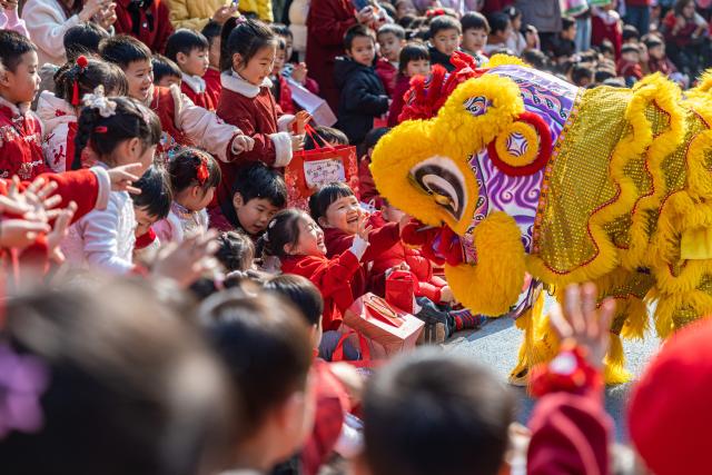 (251231) -- BEIJING, Dec. 31, 2025 (Xinhua) -- Children interact with a lion dancer at a kindergarten in Wenling City, east China's Zhejiang Province, Dec. 30, 2025. Various activities are held across China to celebrate the upcoming new year. (Photo by Xu Weijie/Xinhua)