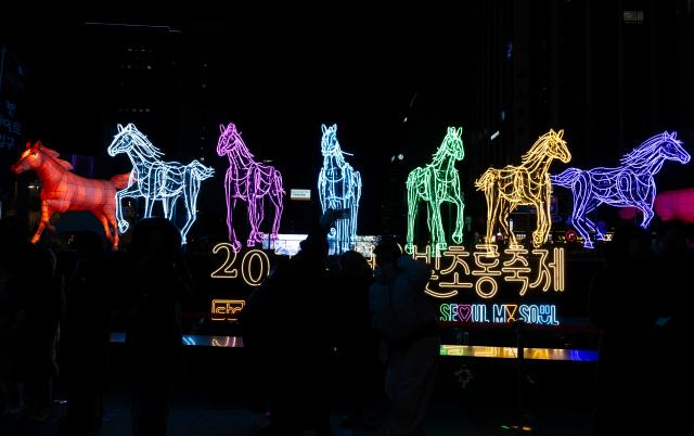 (251231) -- SEOUL, Dec. 31, 2025 (Xinhua) -- People pose for a photo in front of a New Year light display in Seoul, South Korea on Dec. 31, 2025. (Photo by Jun Hyosang/Xinhua)