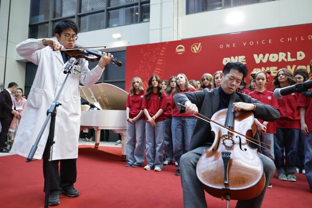 (251231) -- BEIJING, Dec. 31, 2025 (Xinhua) -- Ouyang Quanshi (L) from the Peking Union Medical College Hospital (PUMCH) and Feng Yao, the principal cellist of the Schleswig-Holstein Symphony Orchestra from Germany, perform at the PUMCH in Beijing, capital of China, Dec. 31, 2025. Fifty-six young performers from One Voice Children's Choir along with invited musicians gave a performance at the hospital on Wednesday. (Xinhua/Zhang Yuwei)