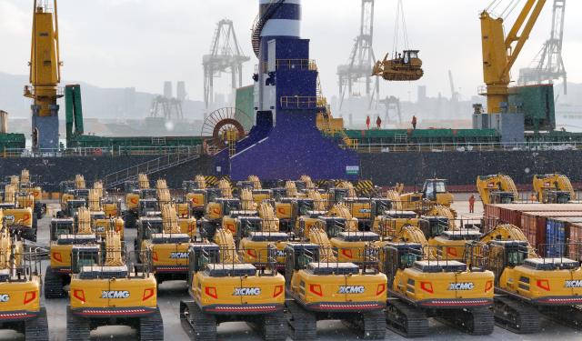 (251231) -- BEIJING, Dec. 31, 2025 (Xinhua) -- A drone photo taken on Dec. 31, 2025 shows China-made construction machinery being loaded for export to Indonesia at Yantai Port in east China's Shandong. As the year draws to a close, companies across the country are ramping up efforts, intensifying production to make a final push. (Photo by Tang Ke/Xinhua)
