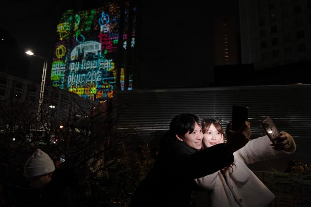 (260101) -- TOKYO, Jan. 1, 2026 (Xinhua) -- People take selfies during a New Year countdown event in Tokyo, Japan, Jan. 1, 2026. (Xinhua/Jia Haocheng)