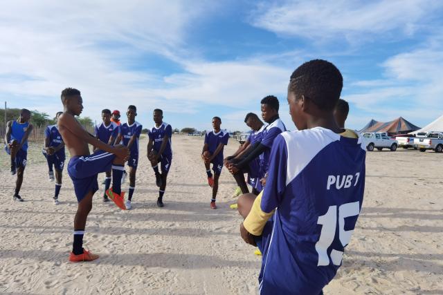 (260101) -- WINDHOEK, Jan. 1, 2026 (Xinhua) -- Players stretch before a match during a grassroots football tournament at a village in the Oshana region in the northern part of Namibia on Dec. 31, 2025. TO GO WITH "Feature: Festive season sparks grassroots football boom in Namibia" (Photo by Ndalimpinga Iita/Xinhua)
