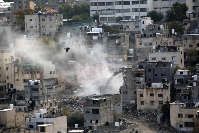 (260101) -- TULKARM, Jan. 1, 2026 (Xinhua) -- An Israeli bulldozer demolishes a Palestinian building in the Nur Shams refugee camp, east of the city of Tulkarm in the West Bank, on Dec. 31, 2025. (Photo by Nidal Eshtayeh/Xinhua)