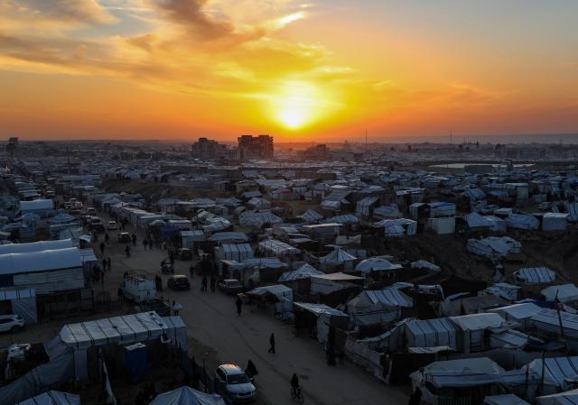 (260101) -- GAZA,  Jan. 1, 2026 (Xinhua) -- A photo taken on Dec. 31, 2025 shows the sunset over a temporary shelter for displaced people in Khan Yunis City in the southern Gaza Strip. (Photo by Rizek Abdeljawad/Xinhua)