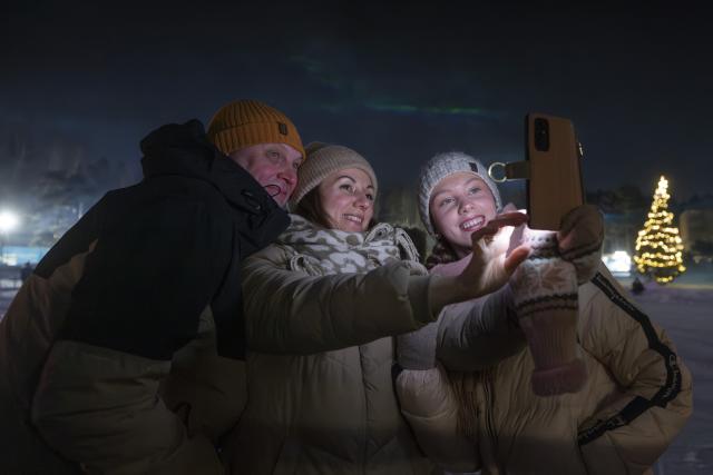 (260101) -- ESPOO, Jan. 1, 2026 (Xinhua) -- People take selfies during a New Year's Eve light show in Espoo, a city in southern Finland, Dec. 31, 2025. (Photo by Matti Matikainen/Xinhua)