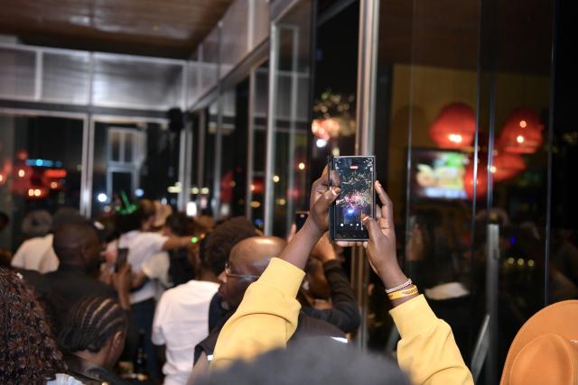 (260101) -- NAIROBI, Jan. 1, 2026 (Xinhua) -- People watch the New Year fireworks show from a rooftop restaurant in Nairobi, capital of Kenya, Jan. 1, 2026. (Xinhua/Liu Qiong)