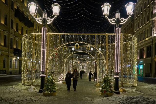 (260101) -- ST. PETERSBURG, Jan. 1, 2026 (Xinhua) -- People walk through a light tunnel on a street of St. Petersburg, Russia, on Dec. 31, 2025. On New Year's Eve, the streets of St. Petersburg were decorated with festive lights. (Photo by Guo Feizhou/Xinhua)