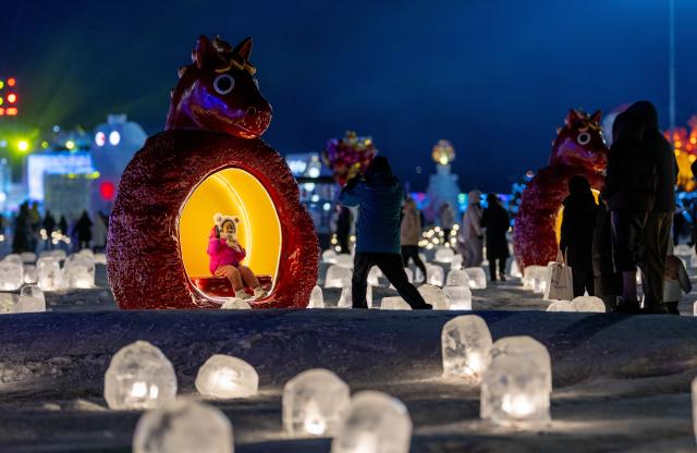 (260101) -- HOHHOT, Jan. 1, 2026 (Xinhua) -- Tourists visit an ice and snow festival at the Daheihe military cultural park in Hohhot, north China's Inner Mongolia Autonomous Region, Dec. 31, 2025.
  The event kicked off on Wednesday, attracting tourists to enjoy lanterns, ice sculptures and snacks. (Xinhua/Lian Zhen)